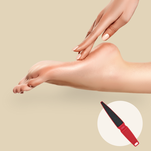 Close-up of a person gently touching their smooth foot with manicured nails and a red foot file inset on beige background