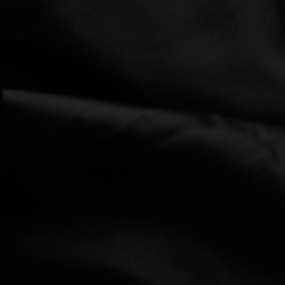 Close-up of smooth black fabric with subtle folds and a soft, matte texture under low light conditions