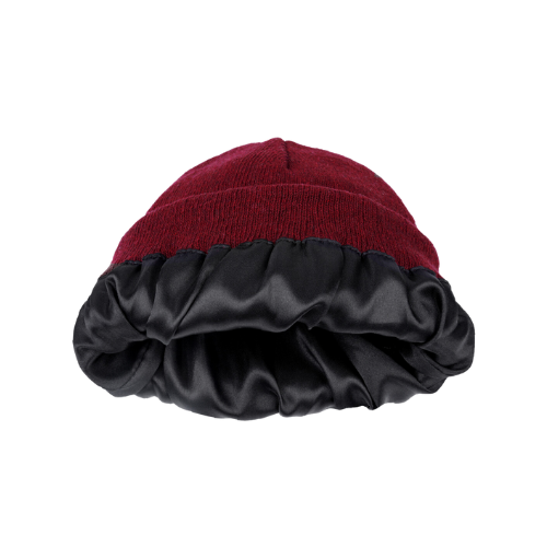 Close-up of a burgundy knit bonnet with black satin lining against a plain white background