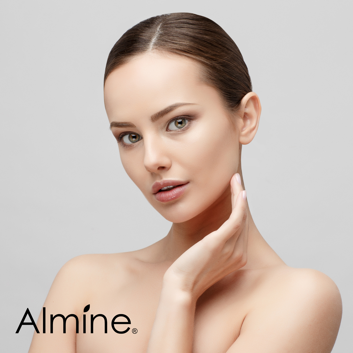 Close-up of woman with clear skin gently touching her face promoting skincare and beauty products by Almine