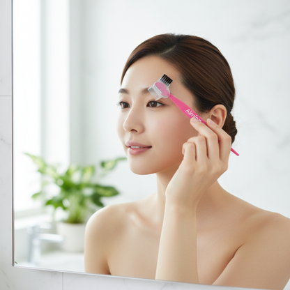 Woman using pink Almine brow trimmer with brush attachment for precise eyebrow grooming in bright bathroom mirror