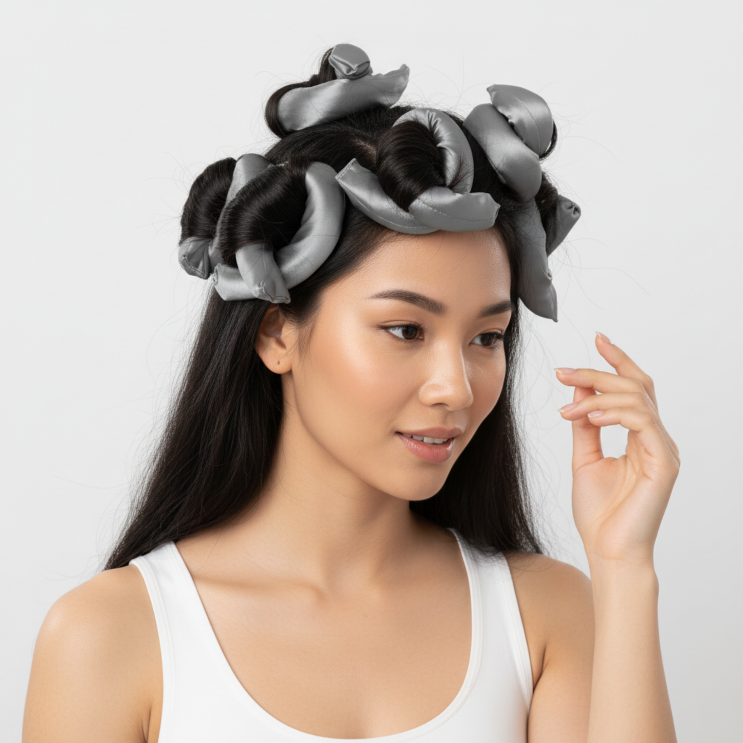 Woman with long dark hair using grey silky satin flexi rods to create curls, showcasing gentle styling tools designed for textured and multicultural hair.