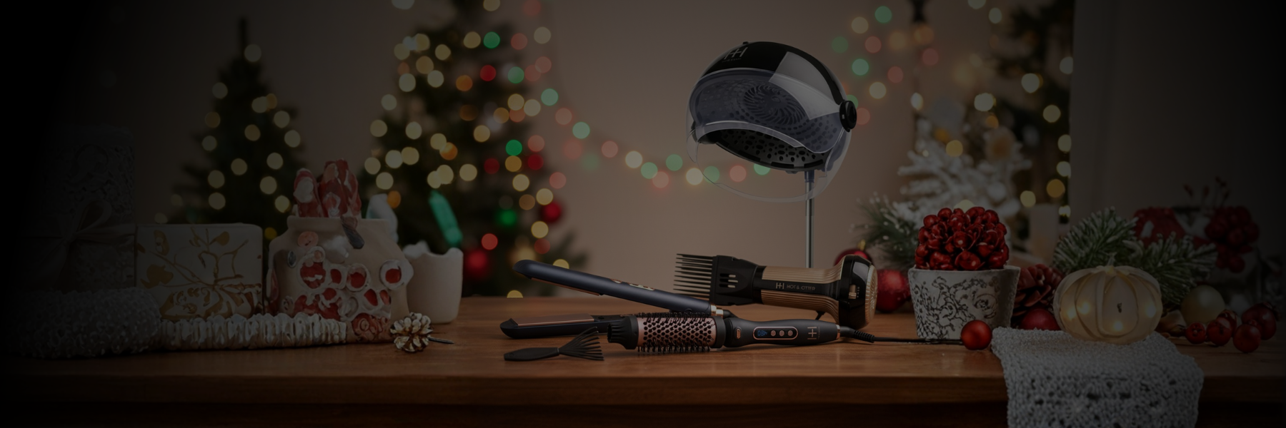 Hair styling tools including a round brush, comb, and curling iron arranged on a wooden table with blurred Christmas decorations in background