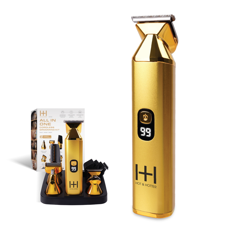 Gold cordless grooming trimmer with digital display and multiple attachments on black base with packaging in background