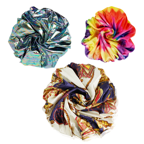 Three colorful scrunchies with metallic, tie-dye, and patterned fabric arranged on white background