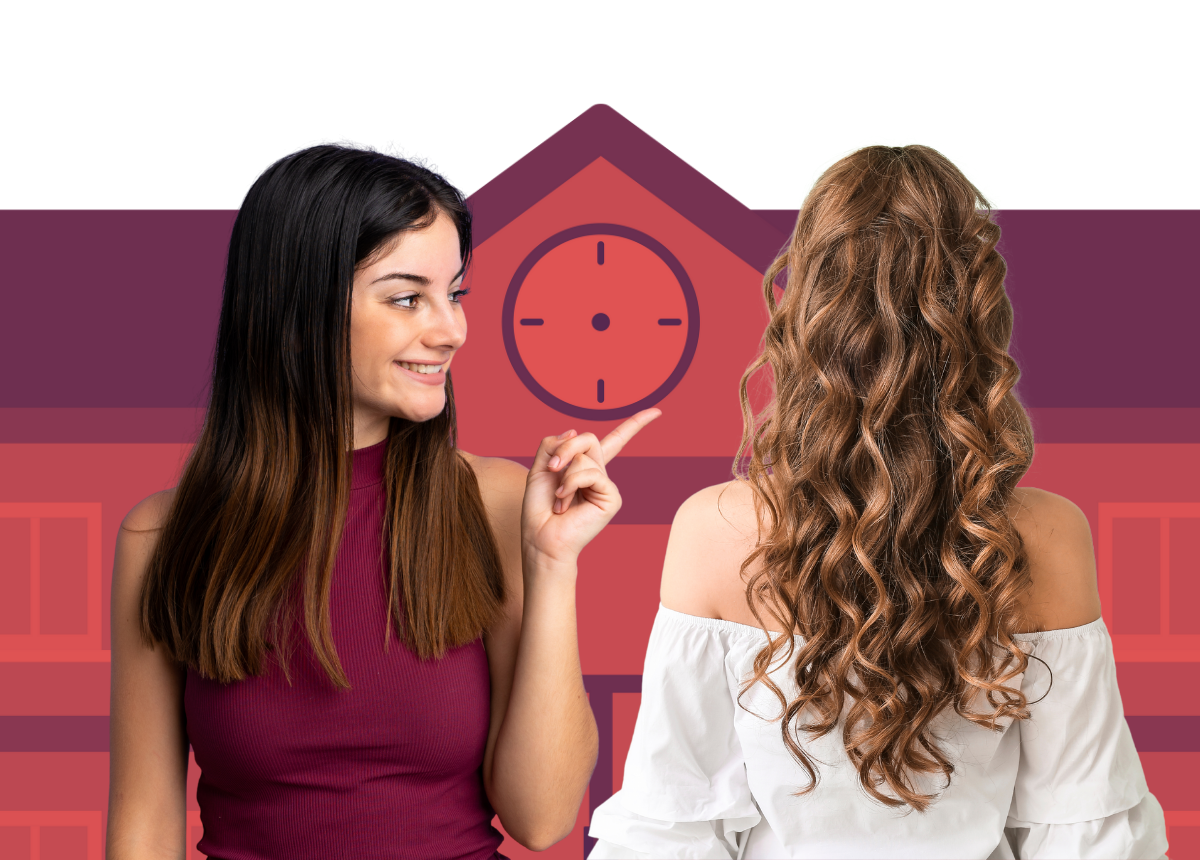 Smiling woman pointing at clock above a school building with another woman showing back with long curly hair