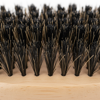 Close-up of mixed boar and nylon bristles densely packed in a light brown wooden base, designed for gentle wave training and styling textured hair by Annie International.