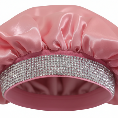 X-large pink satin bonnet with a wide rhinestone-studded elastic band, designed for gentle moisture retention and protection of textured hair during styling and sleep.