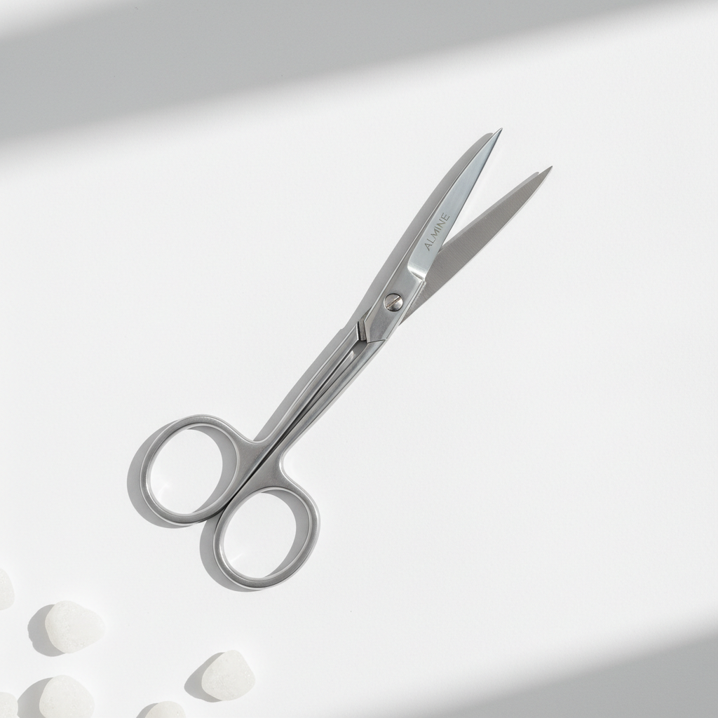 Curved silver nail scissors with a sleek, professional design on a white surface, ideal for precise trimming and neat grooming.