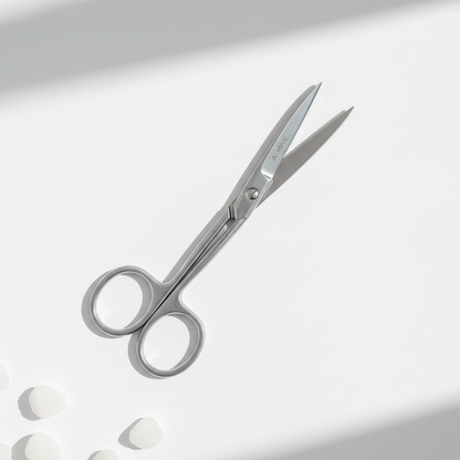 Curved silver nail scissors with a sleek, professional design on a white surface, ideal for precise trimming and neat grooming.