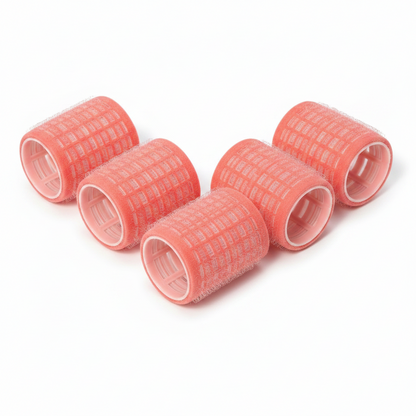 Six pink self-grip hair rollers measuring 1 5/8 inches, featuring a velour texture and hollow core, designed for gentle, no-pin curling on textured and natural hair types.