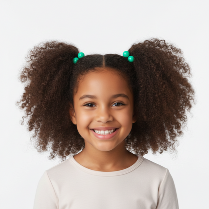 Smiling young girl with natural textured hair styled in two afro puffs secured with bright green twin bead ponytailers designed for multicultural hair.