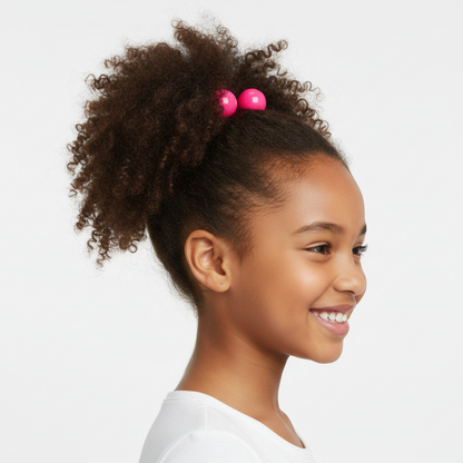 Young girl with natural curly hair styled in a high ponytail secured with bright pink twin bead ponytailers designed for textured, multicultural hair.