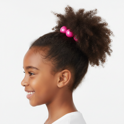 Young girl with natural curly hair styled in a high puff secured by glossy bright pink twin bead ponytailers designed for textured and multicultural hair.