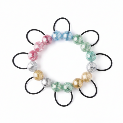 Assorted clear glitter twin bead ponytail holders in red, blue, green, gold, and silver with black elastic bands, designed for textured and multicultural hair by Annie International.