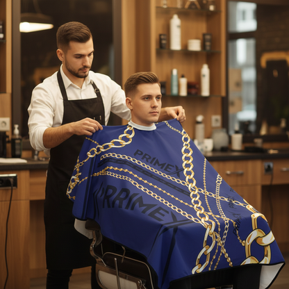 Barber fitting a client with PrimeX Premium Professional Barber Cape, 1 Count, Chains featuring a bold blue fabric adorned with intertwined gold chain patterns in a stylish salon setting.