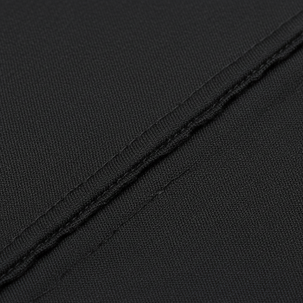 Close-up of black synthetic fabric with smooth, tightly woven texture and clean stitching, designed for a durable kids’ durag supporting wave training and protective styling.