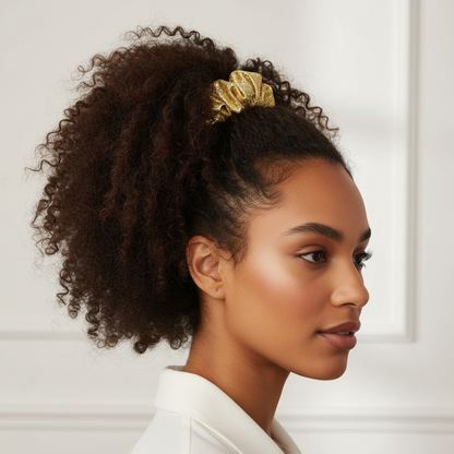 Model with natural textured hair styled in a high puff secured by Annie Metallic Scrunchie 5.5 Inch, 2 Count, Gold, showcasing a shiny, festive hair accessory for versatile styling.