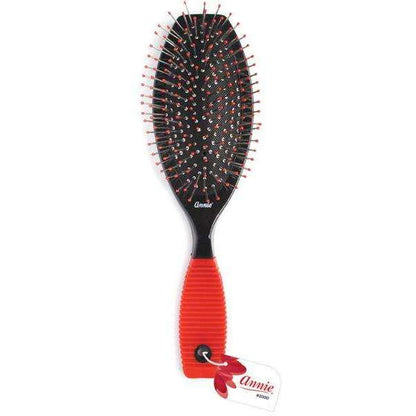 Red-handled wire cushion hair brush with ball-tipped bristles designed for gentle scalp massage and detangling textured and multicultural hair.